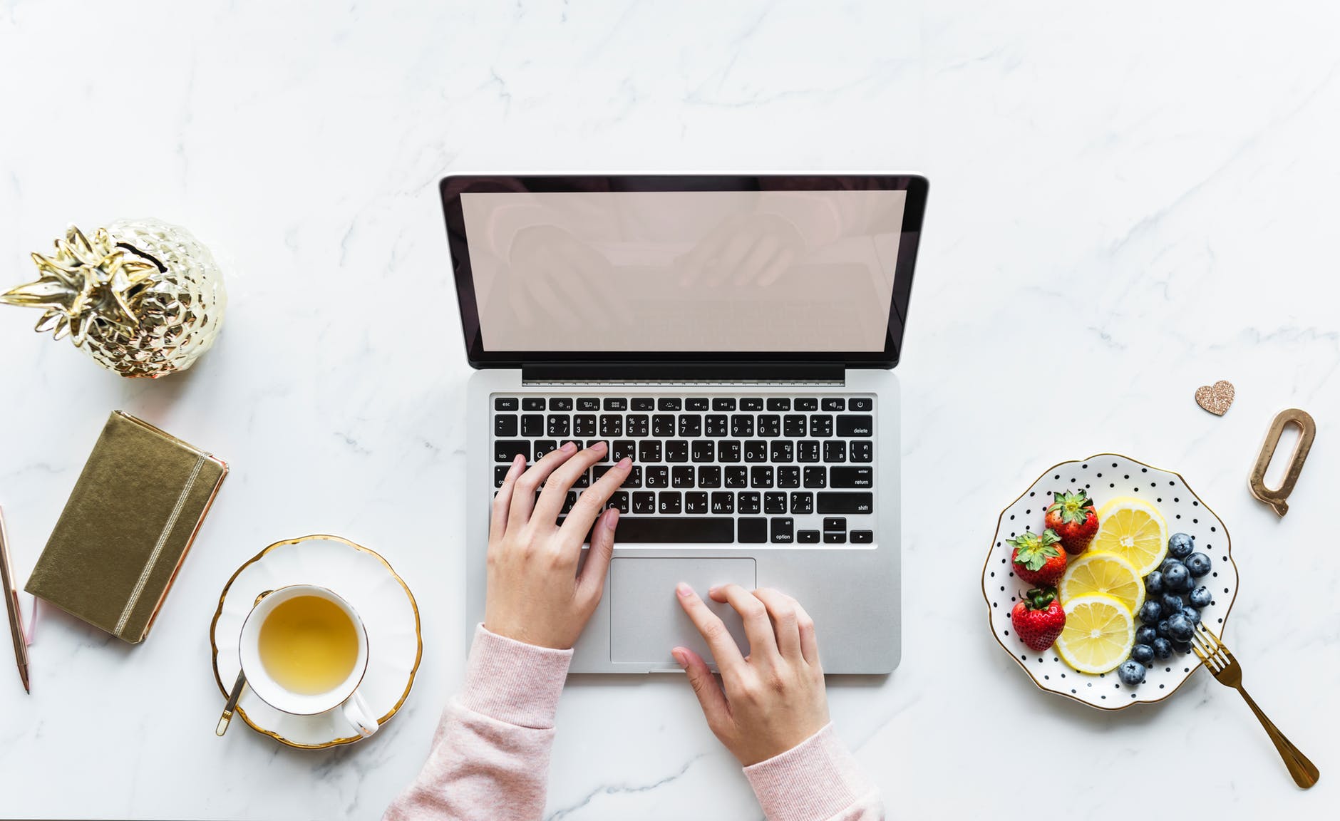 Managing Everything - girl typing on laptop with coffee and fruit